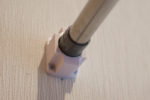 3Dプリントの成功例。物干し竿を掛ける台座（0.2mmピッチ・サポート・PLA・白）。壁に取り付けて、突っ張りポールを差し込んだところ。
